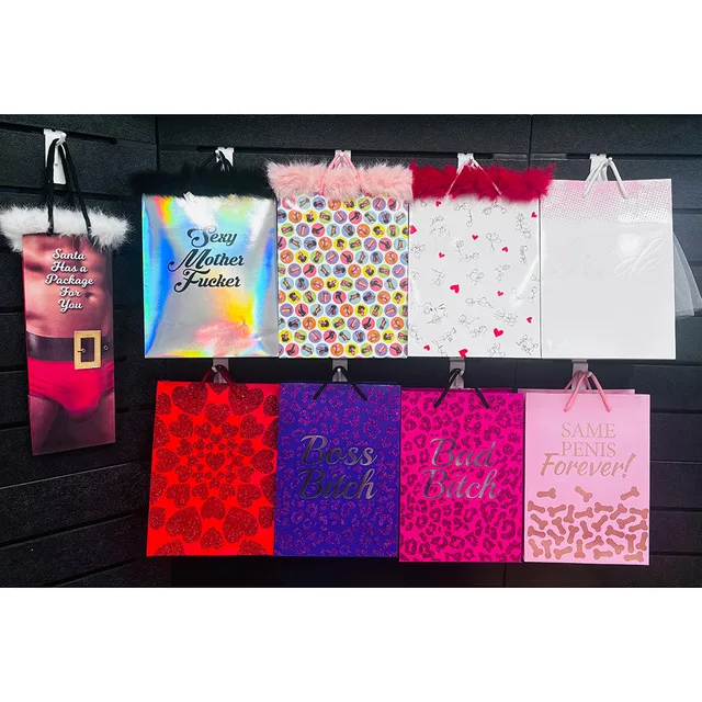 Little Genie nine-style gift bag planogram with assorted printed bags arranged in two rows on black wall panel