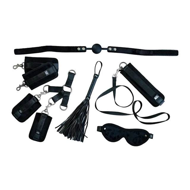 Black cuffs, straps, collar, blindfold and tassel flogger arranged together