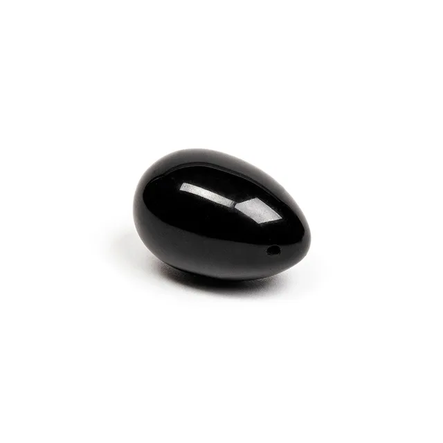 Angled side view of glossy Xaga drilled black obsidian egg