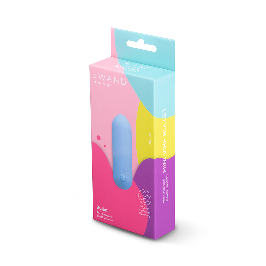 Le Wand Mini Vibe Bullet Blue Le Wand Mini Vibe Bullet beside pink-and-teal retail box