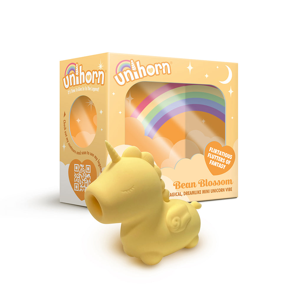 Unihorn Bean Blossom Flicking Vibrator Yellow Creative Conceptions Unihorn Bean Blossom yellow unicorn vibrator beside rainbow retail box