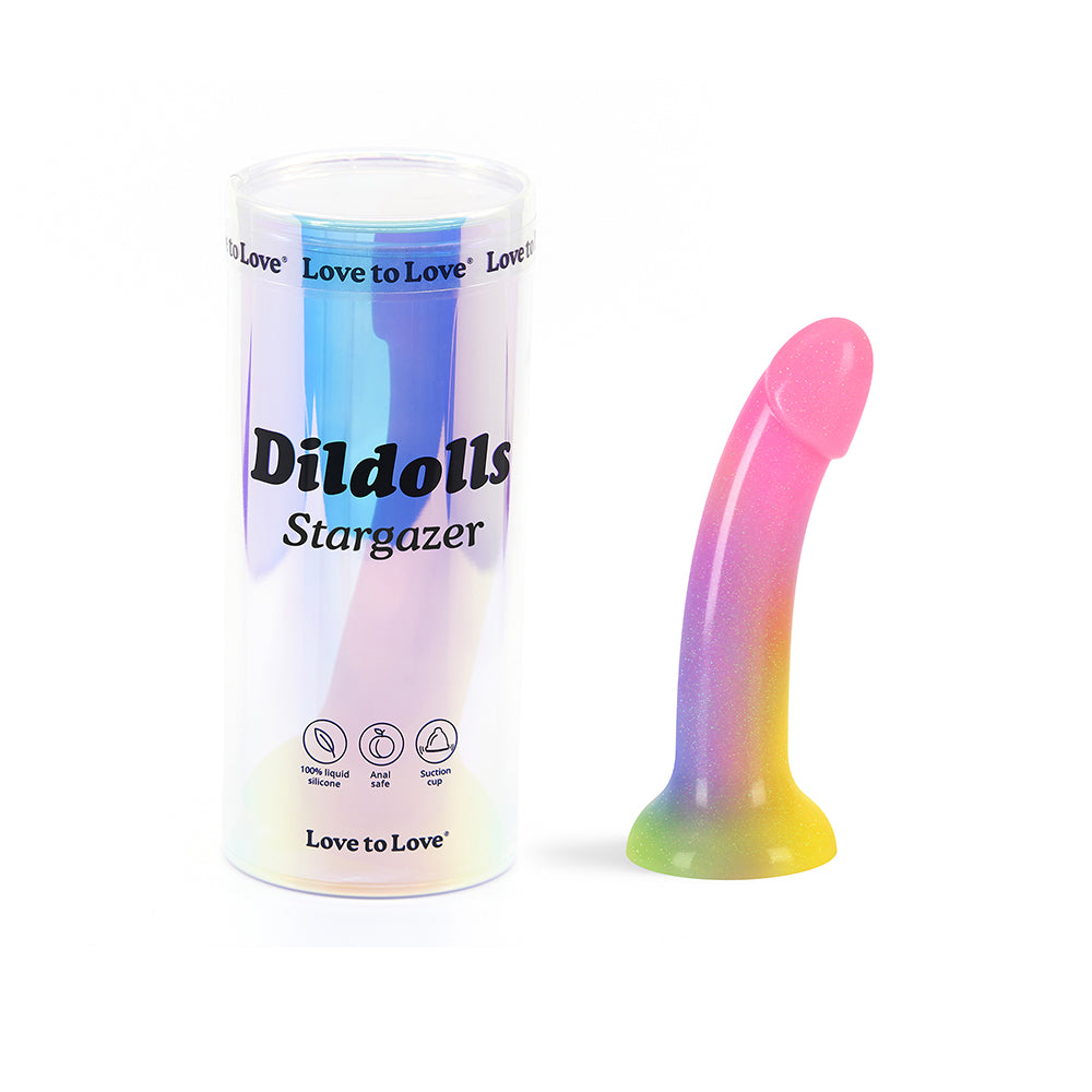 Love to Love Dildolls Stargazer Rainbow and Glitter rainbow-gradient Dildolls Stargazer dildo beside cylindrical package