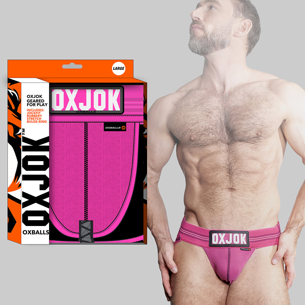 Oxballs Oxjok Slingjock Upthrust Slider-Strap Jock Pink Sky S Oxballs Oxjok bright pink jockstrap worn by model beside orange box