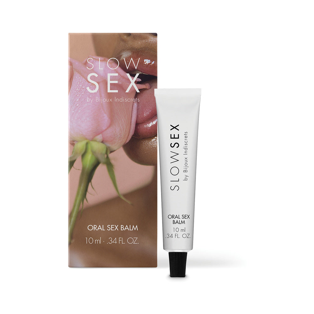 Bijoux Indiscrets Slow Sex Oral Sex Balm 0.34 oz. white Slow Sex Oral Sex Balm tube with black cap beside rose-print retail carton