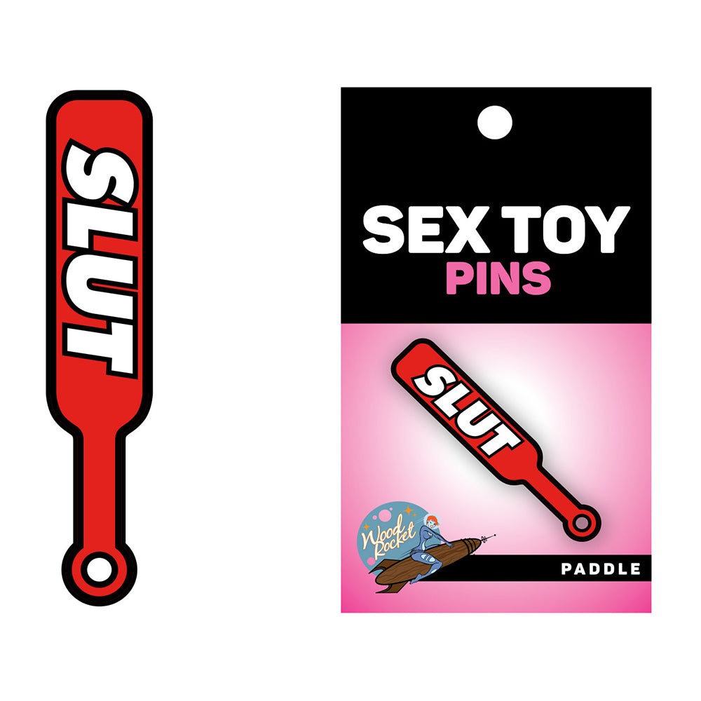 Sex Toy Pin Paddle Slut Wood Rocket red Paddle Slut enamel pin beside retail card