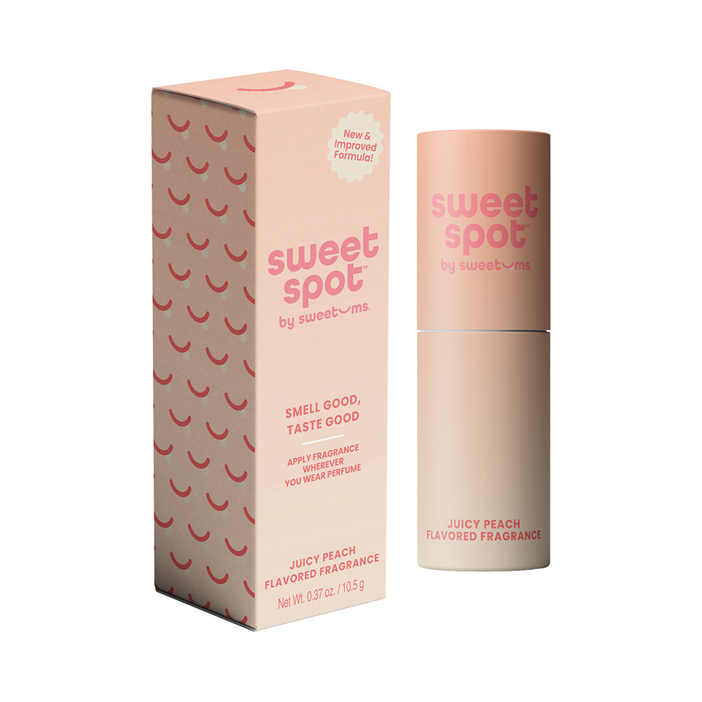 Sweetums Sweet Spot Flavored Fragrance Juicy Peach Sweet Spot Juicy Peach fragrance stick beside peach-pink patterned box