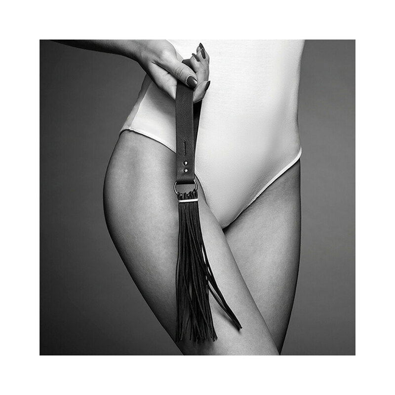Bijoux Indiscrets Maze Tassel Flogger black Maze tassel flogger with flat buckled handle and long narrow tails held by model