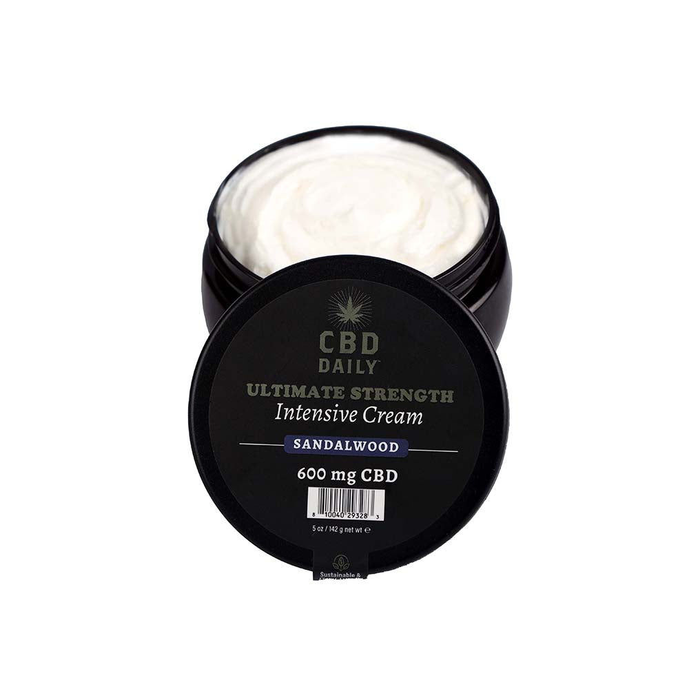 Earthly Body CBD Cream Sandalwood 5 oz. Open black jar of white CBD Daily Sandalwood cream beside lid
