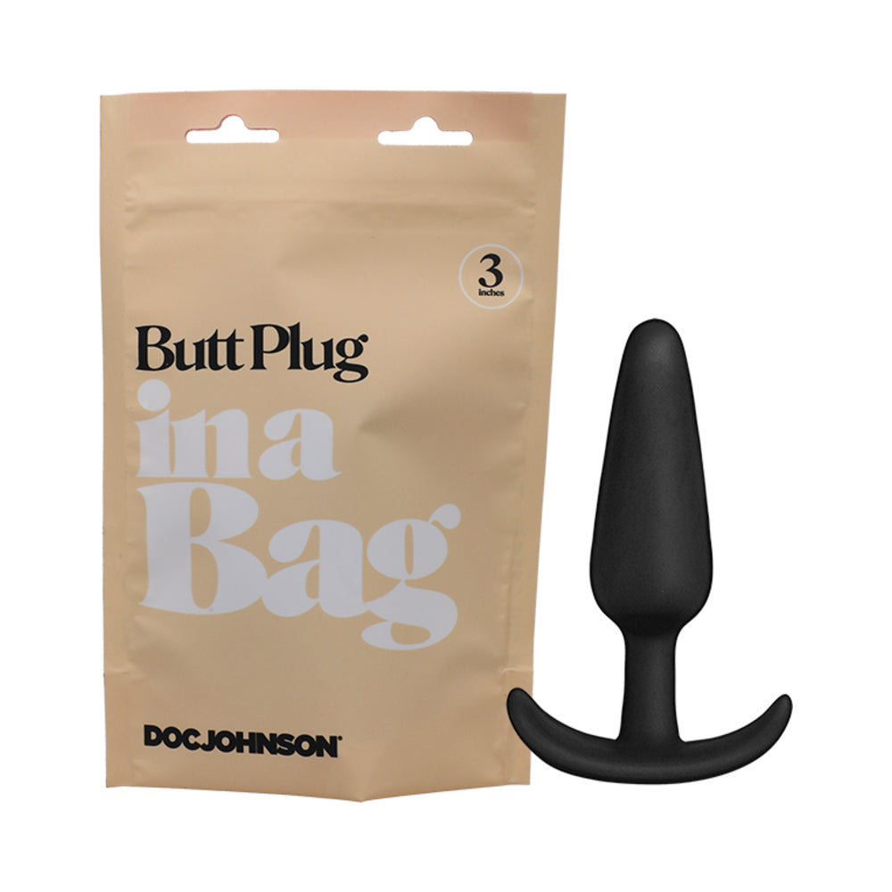 Doc Johnson Butt Plug In A Bag 3 in. Silicone Black Black 3-inch silicone butt plug beside kraft In a Bag pouch