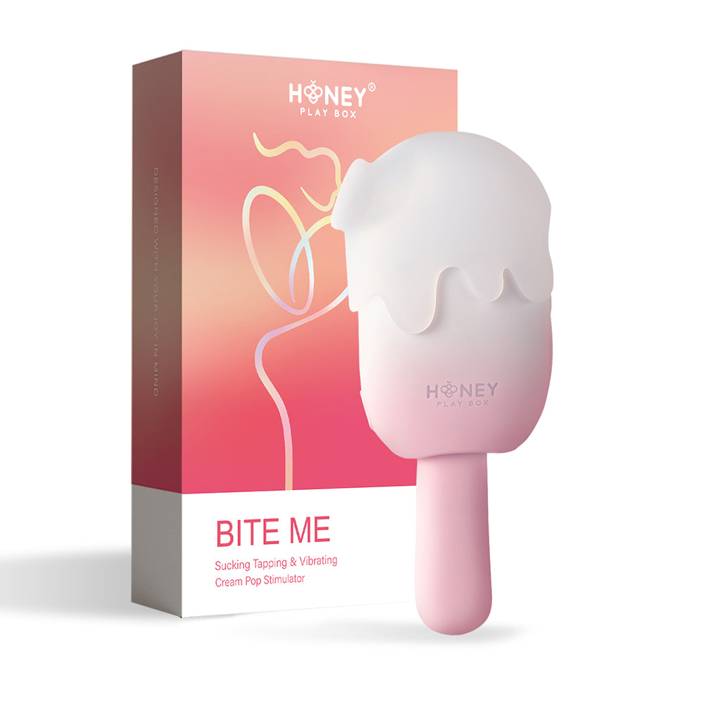 Honey Play Box Bite Me Sucking Tapping & Vibrating Cream Pop Stimulator pink-and-white Bite Me cream-pop stimulator standing beside coral retail box